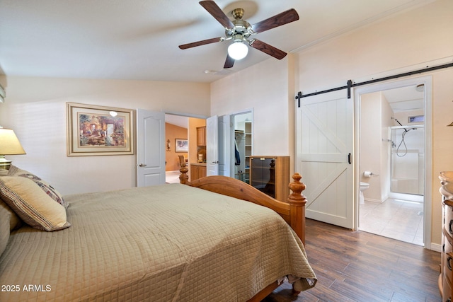 2080 W Pine Grove Dr, Show Low, AZ 85901 - bedroom featuring a barn door, lofted ceiling, wood finished floors, a spacious closet, and ensuite bathroom