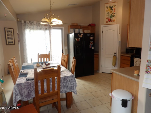 dining space featuring vaulted ceiling, light tile patterned floors, and an inviting chandelier