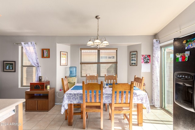 tiled dining room featuring vaulted ceiling, a notable chandelier, and a healthy amount of sunlight