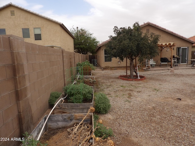 view of yard featuring a patio, a pergola, and central AC