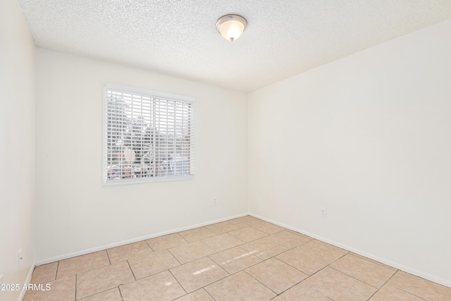 tiled spare room featuring a textured ceiling