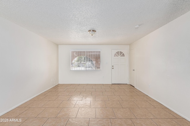 foyer entrance with light tile patterned floors and a textured ceiling