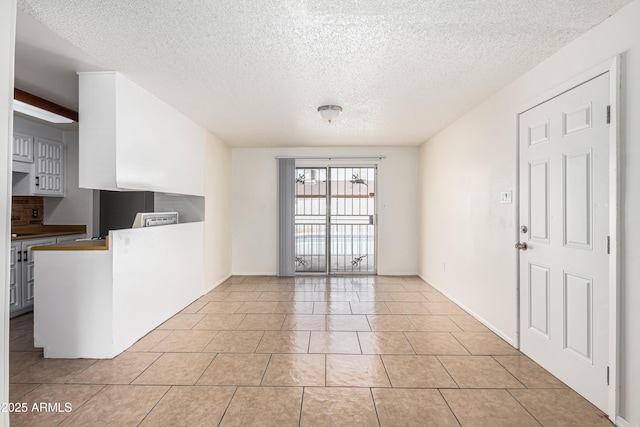 interior space featuring light tile patterned floors and a textured ceiling