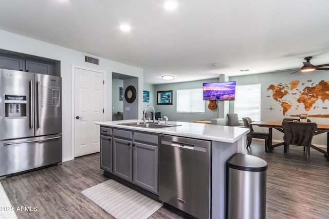 13709 W Rovey Ave, Litchfield Park, AZ 85340 - kitchen with appliances with stainless steel finishes, a sink, gray cabinetry, light countertops, and dark wood-type flooring