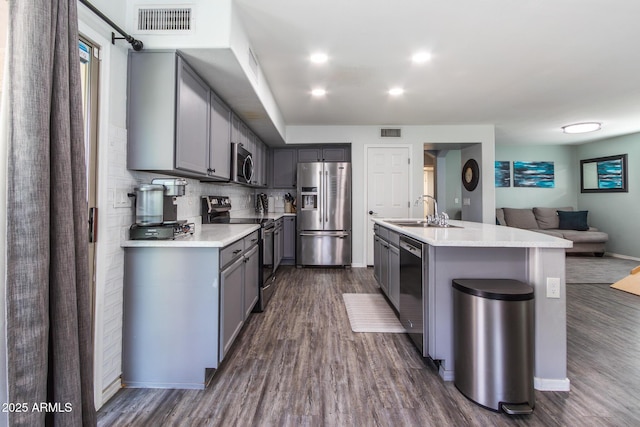 13709 W Rovey Ave, Litchfield Park, AZ 85340 - kitchen featuring stainless steel appliances, gray cabinets, a sink, dark wood-style floors, and open floor plan