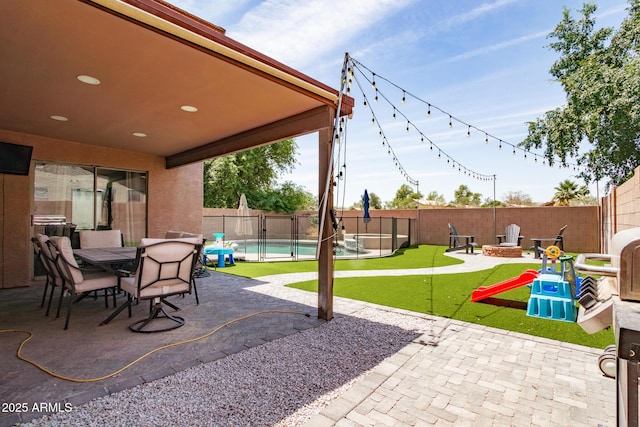 13709 W Rovey Ave, Litchfield Park, AZ 85340 - fenced backyard featuring a patio, a fire pit, a putting green, and outdoor dining space