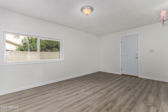 empty room featuring hardwood / wood-style flooring and a textured ceiling