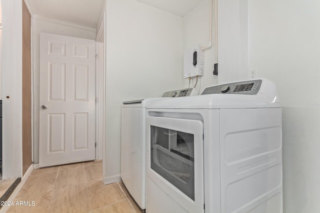 clothes washing area featuring separate washer and dryer and light tile flooring