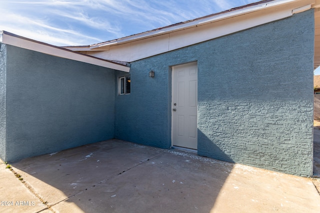 view of exterior entry with a patio