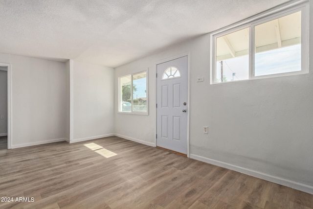 entrance foyer with wood-type flooring and a textured ceiling