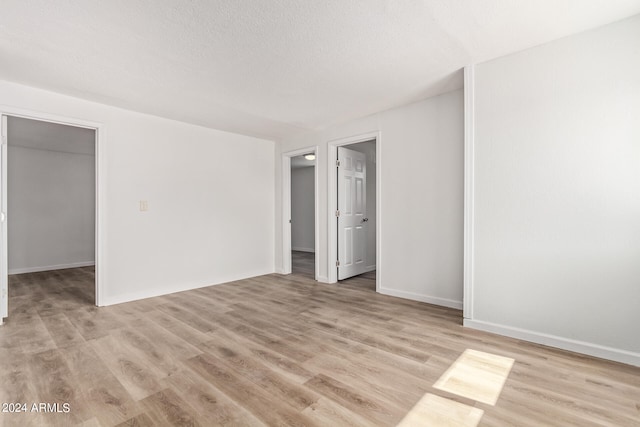 spare room with light hardwood / wood-style flooring and a textured ceiling