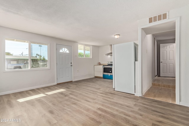 foyer entrance featuring light hardwood / wood-style floors and a textured ceiling