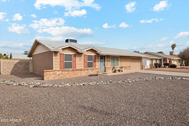 single story home with cooling unit and a garage