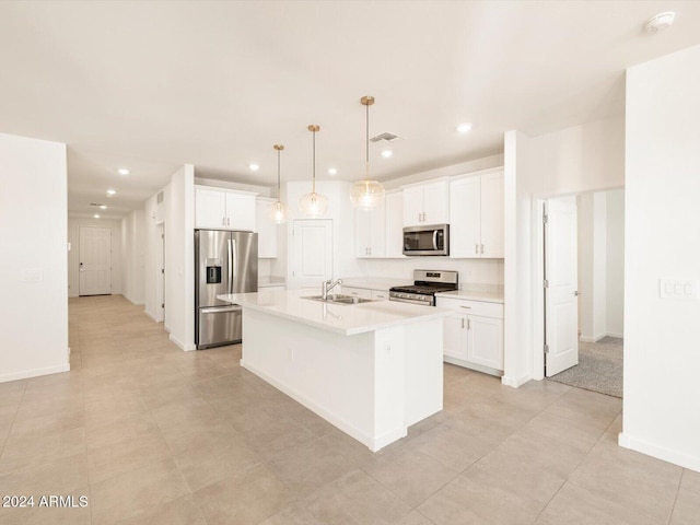 kitchen with white cabinets, appliances with stainless steel finishes, and a kitchen island with sink