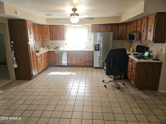 kitchen with decorative backsplash, appliances with stainless steel finishes, light tile patterned floors, and ceiling fan