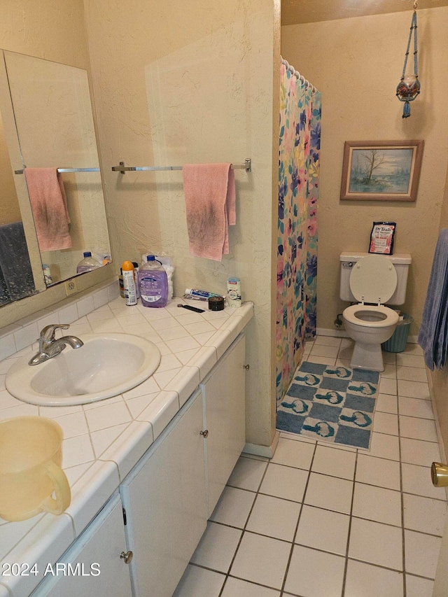 bathroom featuring vanity, a shower with curtain, toilet, and tile patterned floors