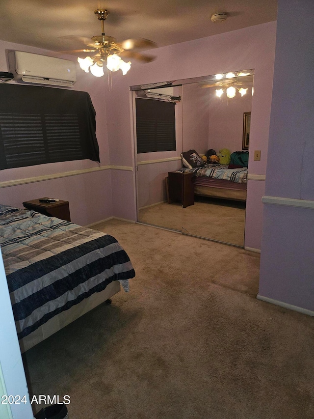 carpeted bedroom with a closet, ceiling fan, and a wall unit AC