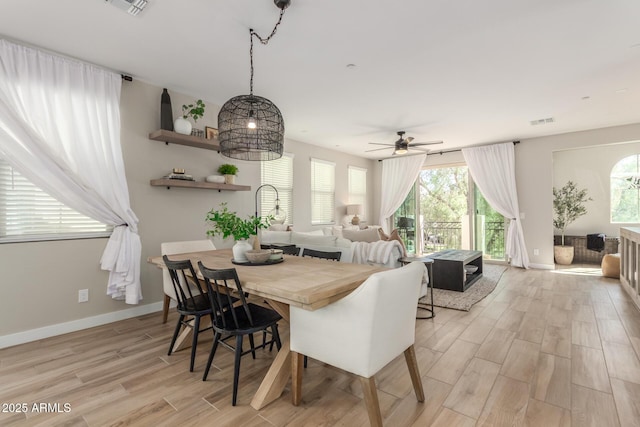 dining space with a wealth of natural light, visible vents, light wood-style flooring, and baseboards