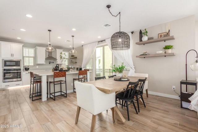 dining area featuring baseboards, light wood-type flooring, visible vents, and recessed lighting