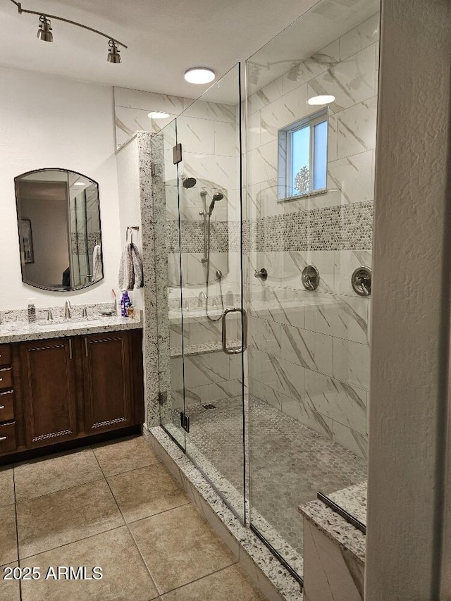 bathroom featuring tile patterned flooring, vanity, and walk in shower