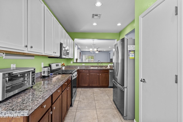 kitchen featuring a sink, white cabinets, a chandelier, stainless steel appliances, and recessed lighting