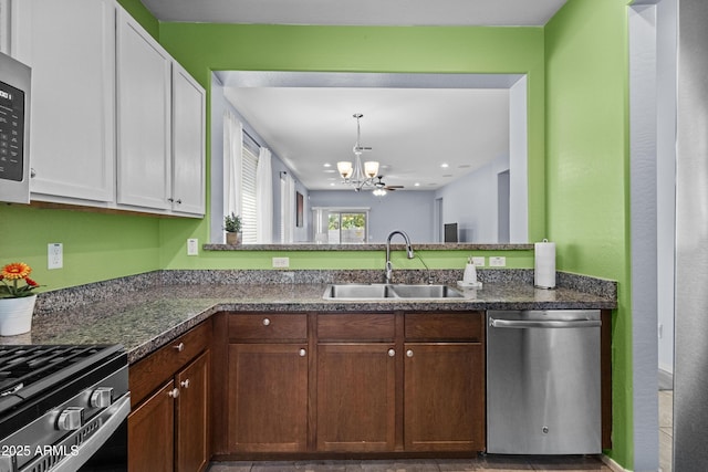 kitchen with pendant lighting, white cabinetry, a sink, dishwasher, and a notable chandelier