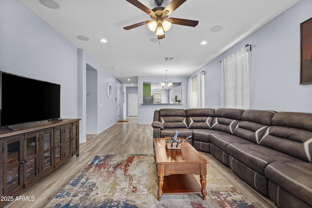 living area featuring recessed lighting, ceiling fan with notable chandelier, light wood finished floors, and visible vents