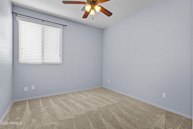 spare room with baseboards, ceiling fan, and carpet