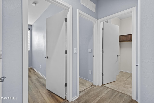 hallway with visible vents and light wood-style flooring