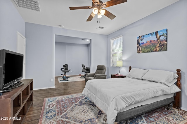 bedroom featuring visible vents, a ceiling fan, baseboards, and wood finished floors