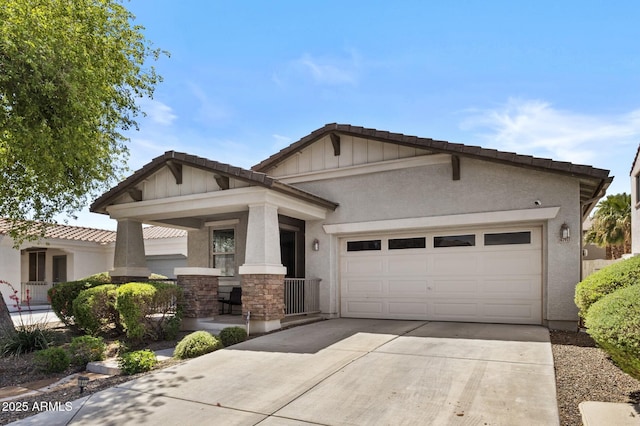 craftsman-style house featuring a tiled roof, covered porch, a garage, concrete driveway, and stucco siding