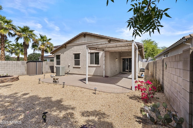 rear view of house with a patio, a fenced backyard, central AC, and stucco siding