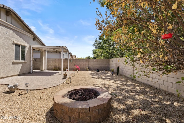 view of yard featuring a fenced backyard, a fire pit, and a patio area