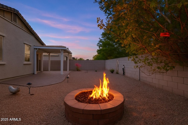 view of yard with a fenced backyard, a patio, and a fire pit