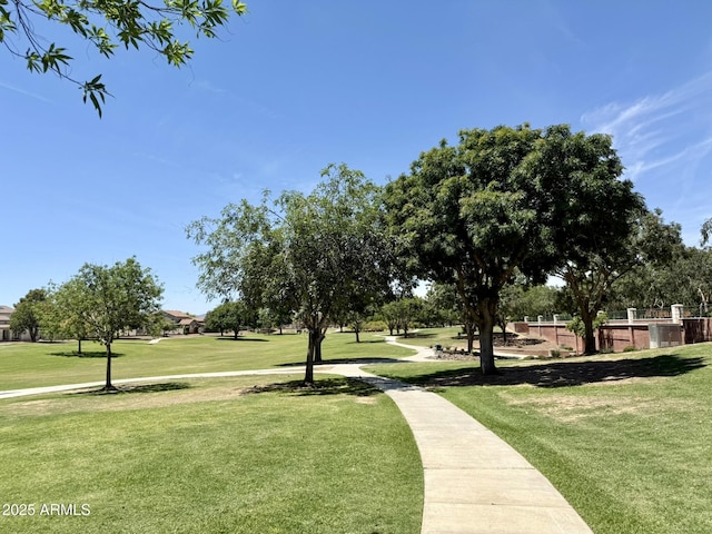 view of property's community with a yard and fence