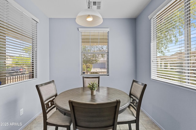 dining space featuring visible vents, baseboards, light tile patterned floors, and a wealth of natural light