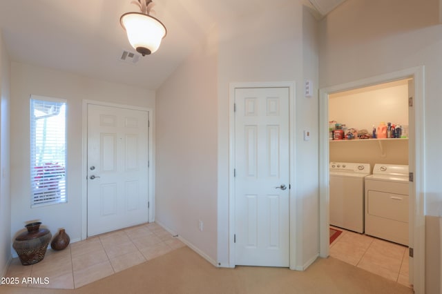 foyer entrance with light tile patterned flooring and independent washer and dryer