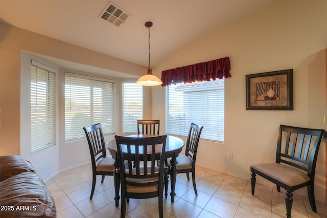 tiled dining room featuring vaulted ceiling