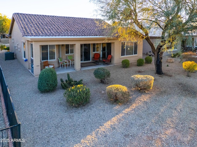 back of property with a patio and central AC