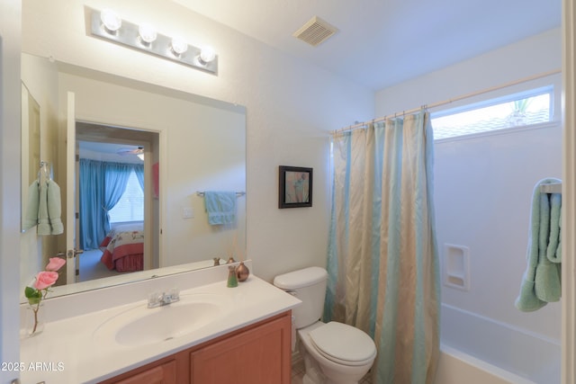 full bathroom featuring shower / bath combo, vanity, toilet, and plenty of natural light