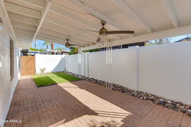 view of patio featuring ceiling fan, a fenced backyard, and a gate