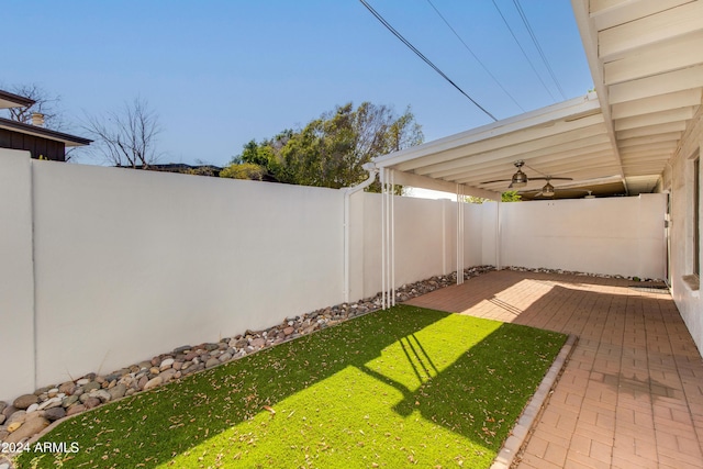 view of yard featuring a patio area, a fenced backyard, and ceiling fan