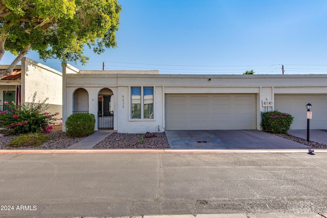 view of property featuring concrete driveway, an attached garage, and stucco siding