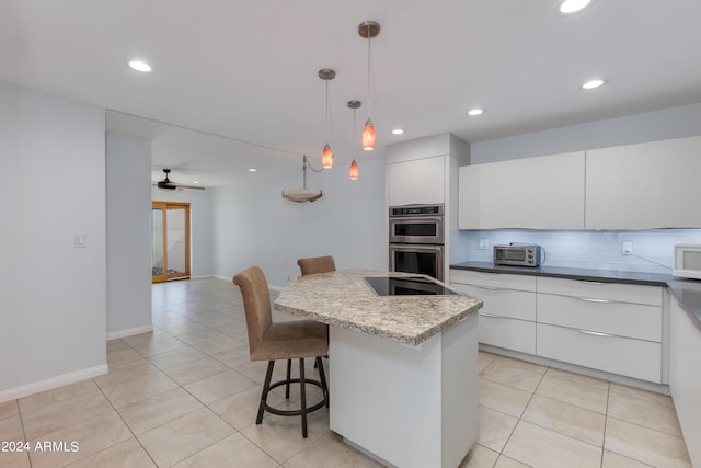 kitchen with a kitchen breakfast bar, double oven, modern cabinets, and white cabinets