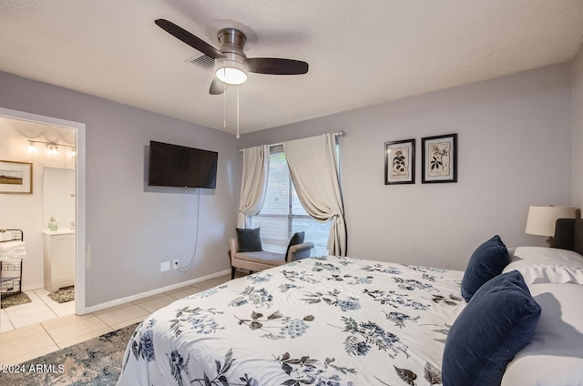 bedroom with ceiling fan, light tile patterned floors, and ensuite bathroom