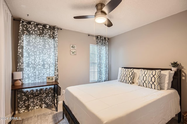 bedroom featuring tile patterned flooring, a textured ceiling, and ceiling fan