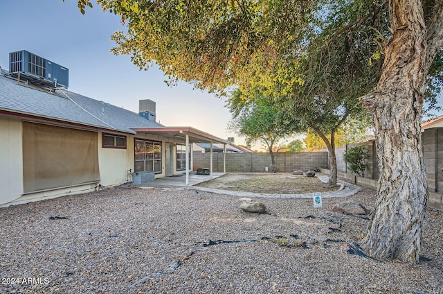 yard at dusk featuring a patio area and cooling unit