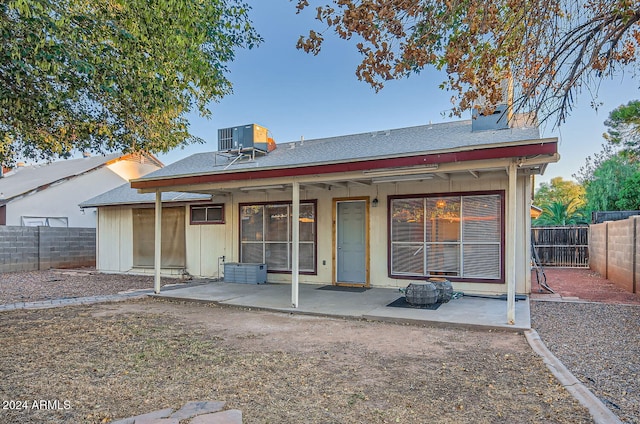 back of property with central air condition unit and a patio area