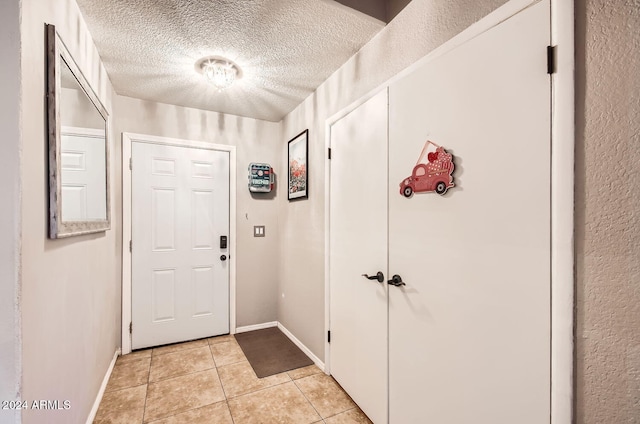 entryway with light tile patterned floors and a textured ceiling