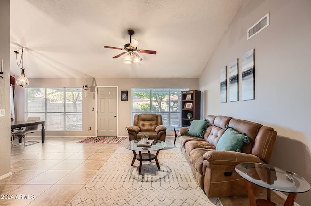 tiled living room with a textured ceiling, ceiling fan, and lofted ceiling